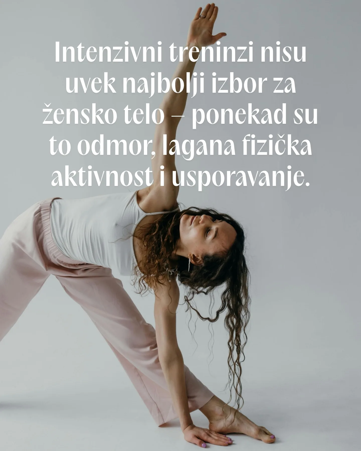 Žena u beloj yoga odeći izvodi asanu trougao.