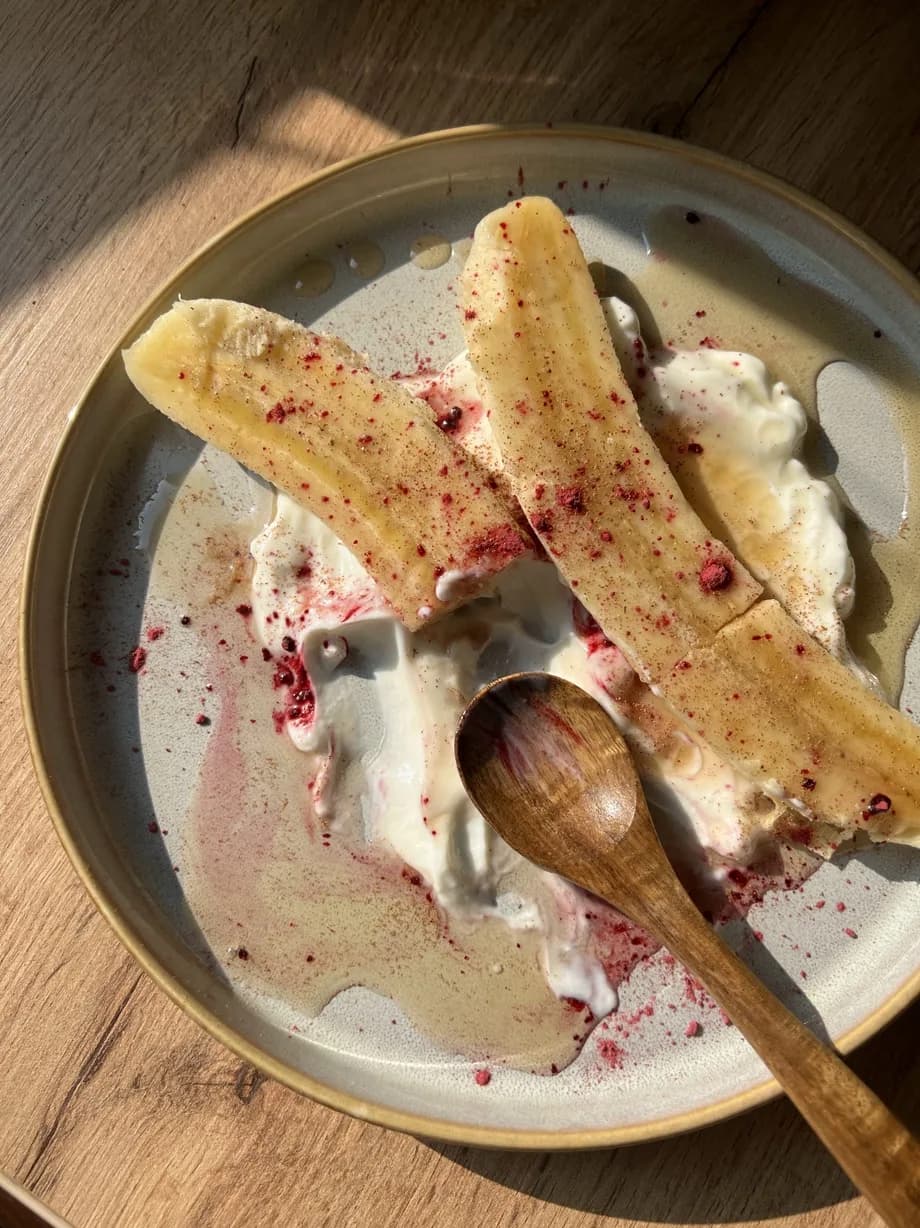 Banana sa jogurtom i voćnim posipom na tanjiru.