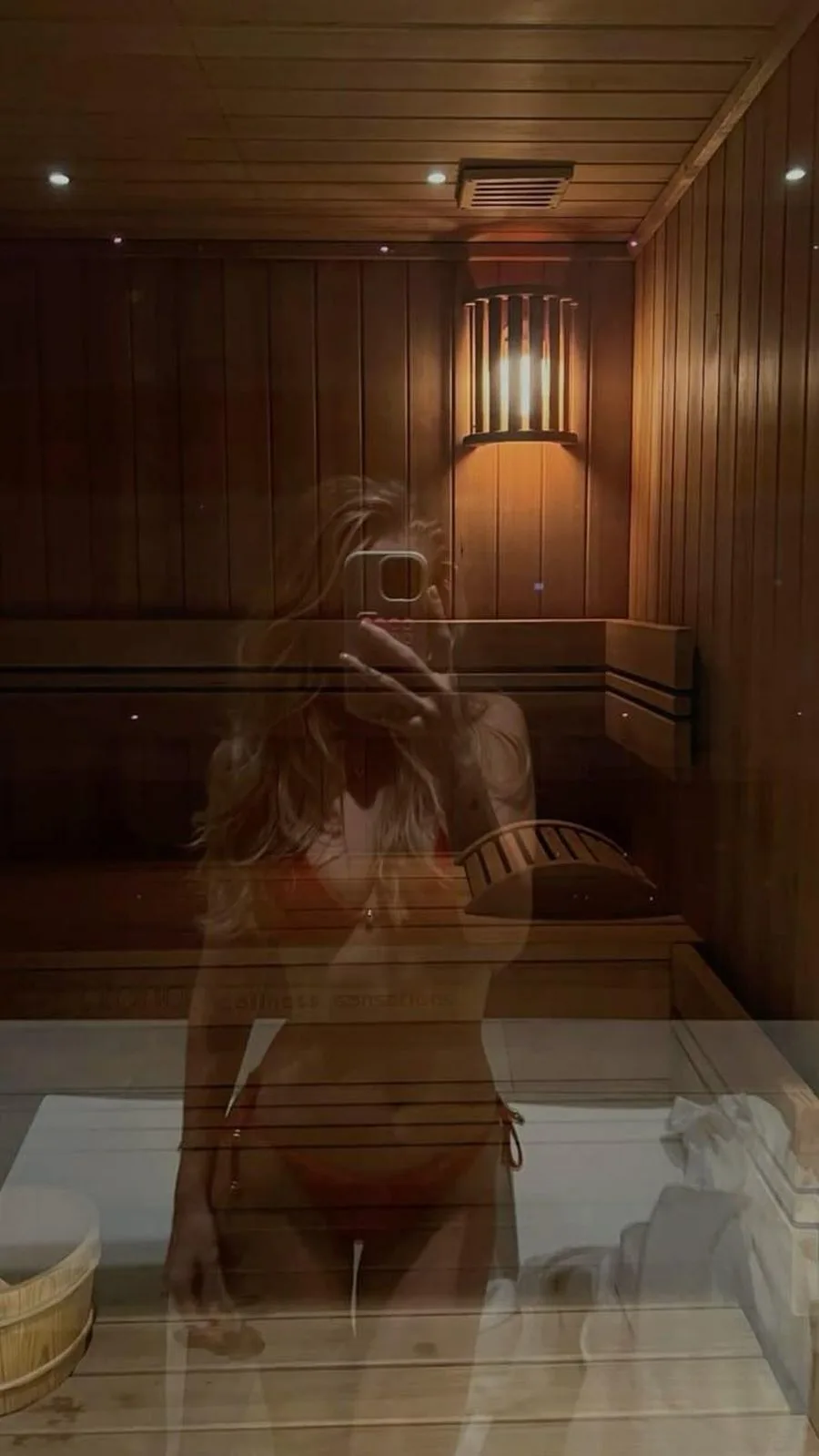 Devojka u kupaćem kostimu ispred ogledala slika selfie